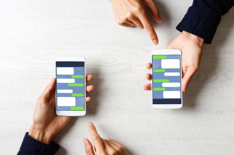 スマートフォンでLINEを操作する人々