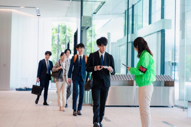 スマートフォンを使用して入場受付をする女性