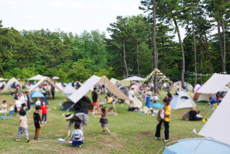 テントのある屋外イベントを楽しむ人々